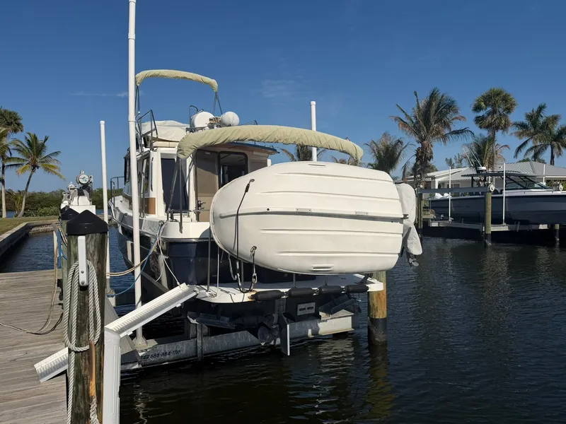 Slide: The Image of 2013 Ranger Tugs R-31 CB at dock with palm trees in background. - 4