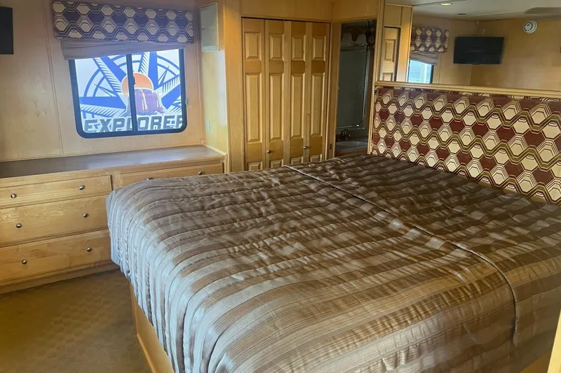 Slide: The Image of Cozy bedroom interior on American Waterways Sundancer Trip #3, featuring a patterned headboard and window view. - 12