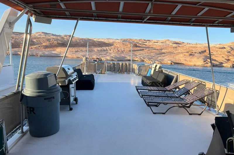 Slide: The Image of Spacious deck of 2007 American Waterways Sundancer, featuring lounge chairs and a grill, overlooking scenic waters. - 20