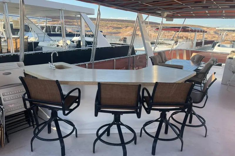 Slide: The Image of Outdoor bar area on a 2007 American Waterways Sundancer houseboat, featuring bar stools and scenic views. - 21