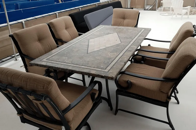 Slide: The Image of Outdoor dining set with cushioned chairs and a stone table on a boat deck, American Waterways 2007. - 24