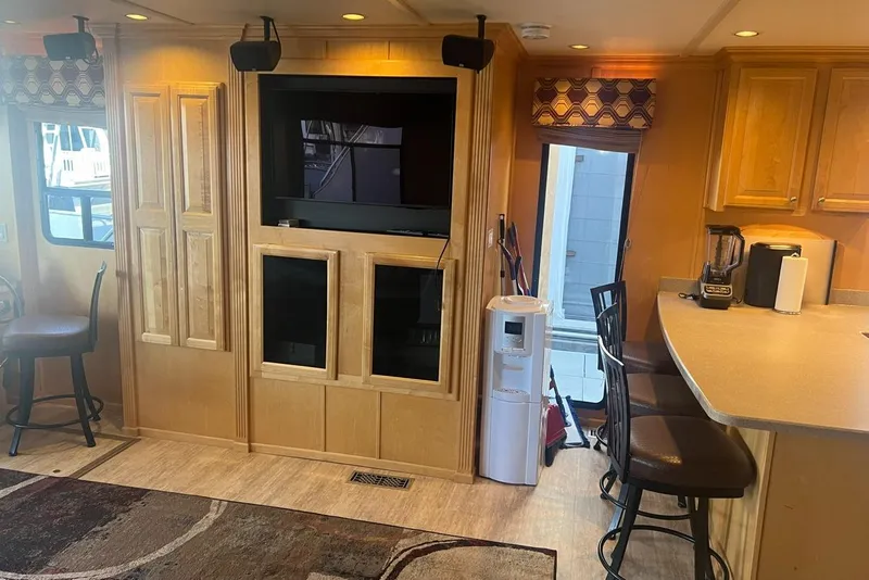 Slide: The Image of Interior of 2007 American Waterways Sundancer, featuring a cozy living area with TV and kitchen counter. - 8