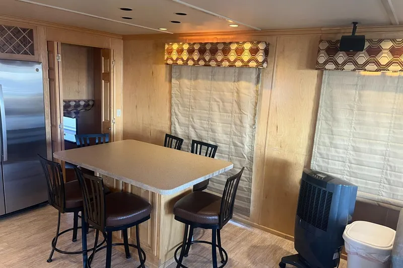Slide: The Image of Modern houseboat interior with dining area, featuring a table, chairs, and stainless steel appliances. - 9