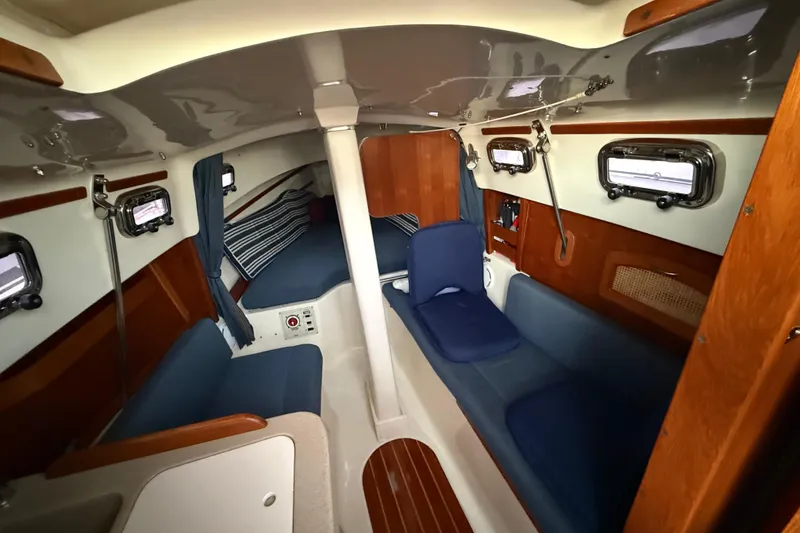 Slide: The Image of Interior of 2013 Hake Seaward 26RK sailboat, featuring cozy seating and wooden accents. - 25