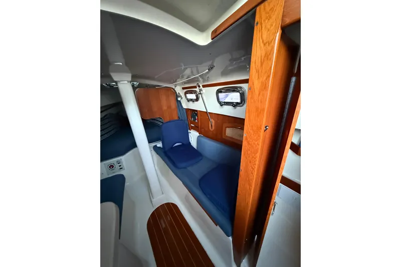 Slide: The Image of Interior of 2013 Hake Seaward 26RK sailboat with blue cushions and wooden accents. - 27