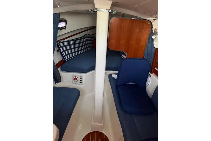 Slide: The Image of Interior of 2013 Hake Seaward 26RK sailboat, featuring cozy seating and striped cushions. - 28