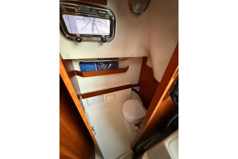 Slide: The Image of Compact bathroom in 2013 Hake Seaward 26RK sailboat with porthole and wooden accents. - 30