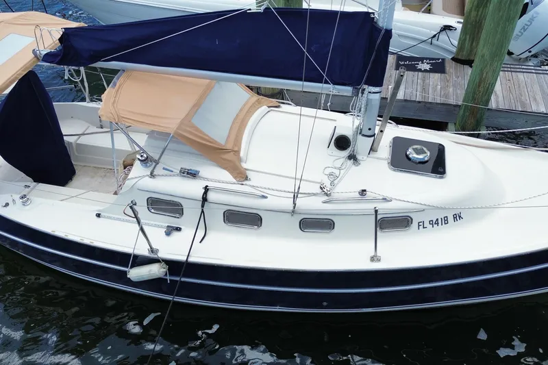Slide: The Image of 2013 Hake Seaward 26RK sailboat docked, featuring tan canopy and blue accents. - 31