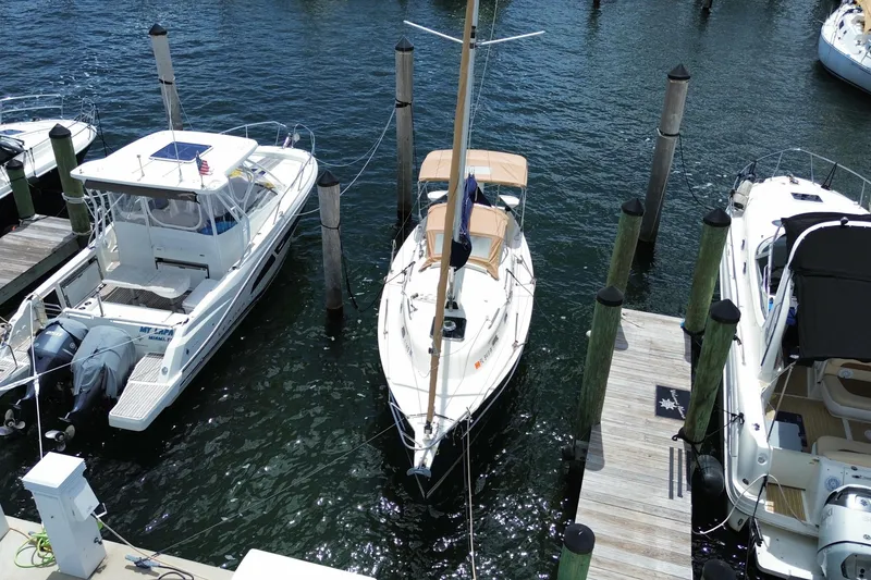 Slide: The Image of 2013 Hake Seaward 26RK sailboat docked between motorboats in a marina. - 32