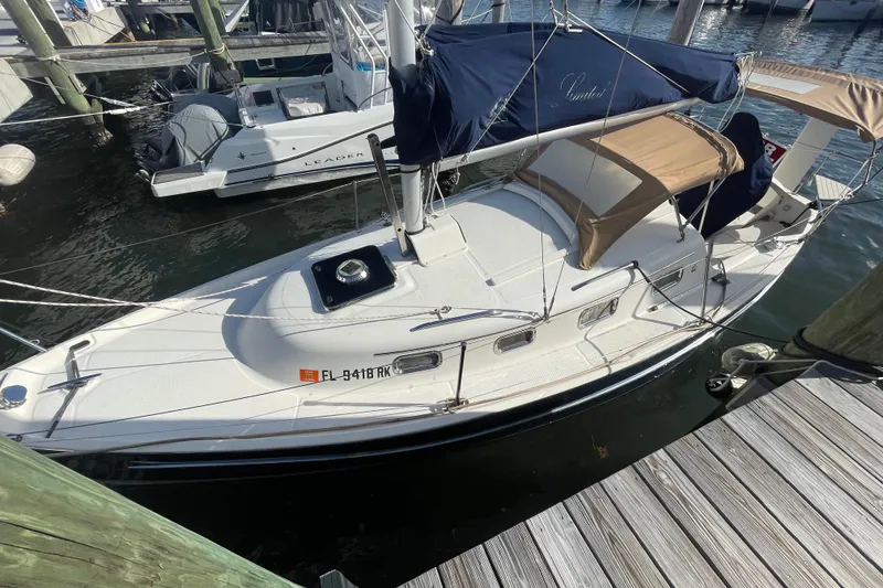Slide: The Image of 2013 Hake Seaward 26RK sailboat docked at marina, featuring blue and tan covers. - 4