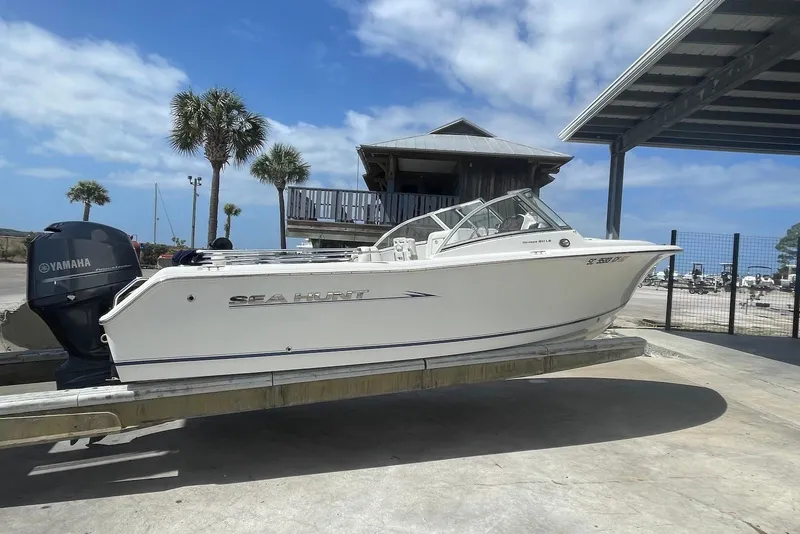 Slide: The Image of 2013 Sea Hunt Escape 211 LE boat on trailer with Yamaha engine, under clear blue sky. - 1