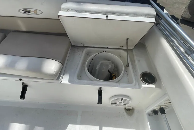 Slide: The Image of 2013 Sea Hunt Escape 211 LE boat interior with open storage compartment and seating. - 11