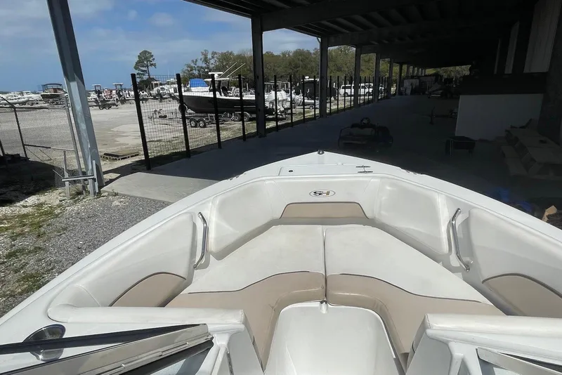 Slide: The Image of 2013 Sea Hunt Escape 211 LE boat docked in a marina under a covered area. - 4