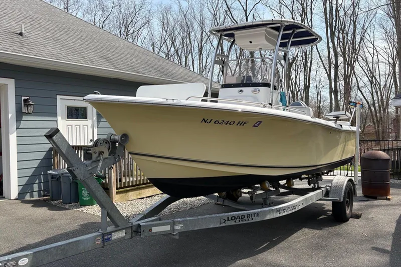 The Image of 2014 Sea Hunt Triton 202 boat on trailer, parked near a house. - 4