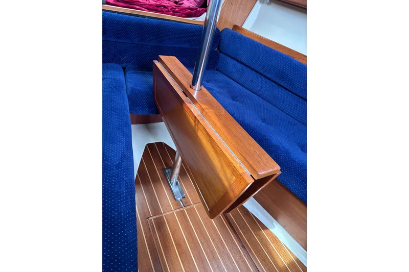 Slide: The Image of Interior of 1986 Pearson 28 sailboat with blue upholstery and wooden table. - 10