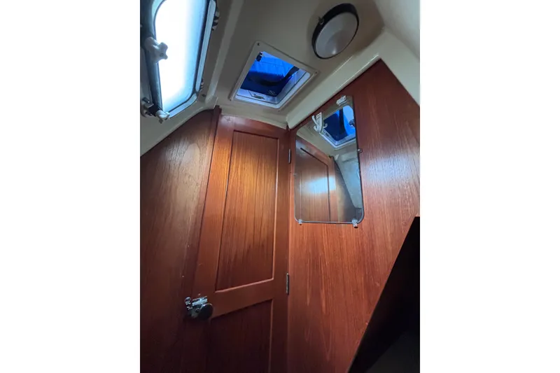 Slide: The Image of Interior of 1986 Pearson 28 sailboat with wooden door and porthole windows. - 12