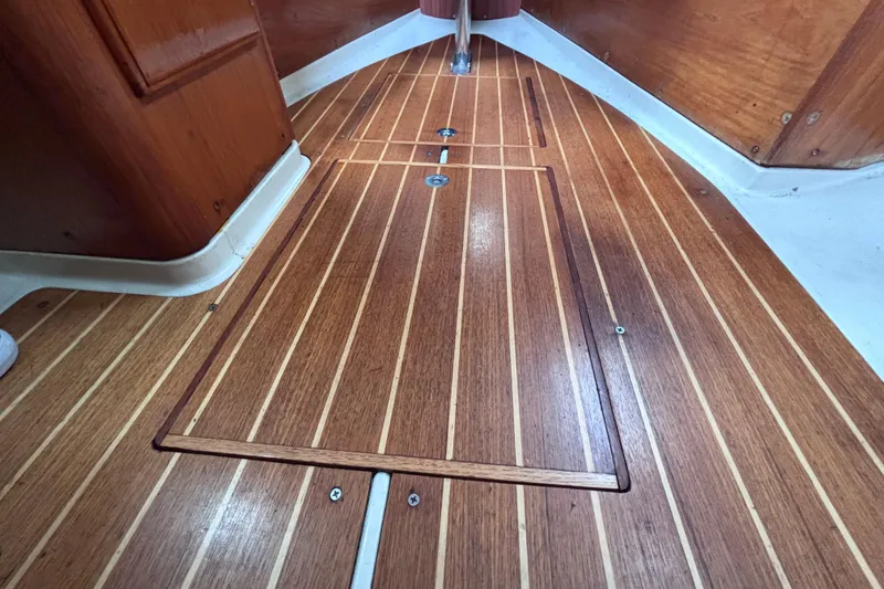 Slide: The Image of Teak wood flooring inside a 1986 Pearson 28 sailboat cabin. - 13