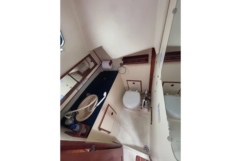 Slide: The Image of 1986 Pearson 28 sailboat bathroom with sink, toilet, and mirror. - 14
