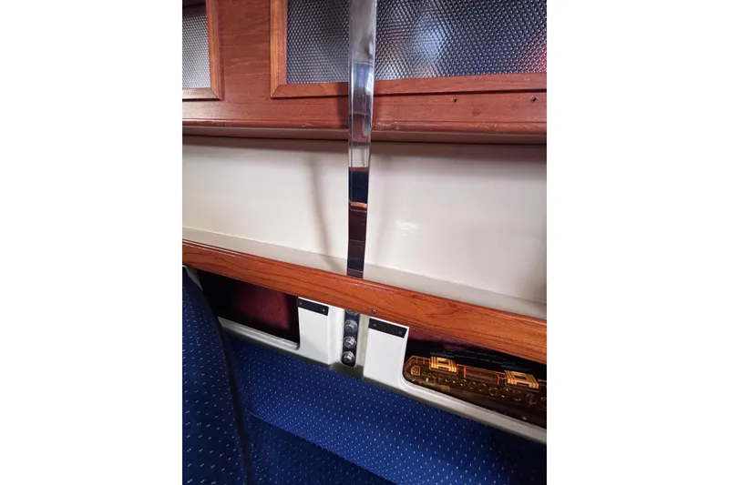 Slide: The Image of Interior of a 1986 Pearson 28 sailboat with wood paneling and blue upholstery. - 15
