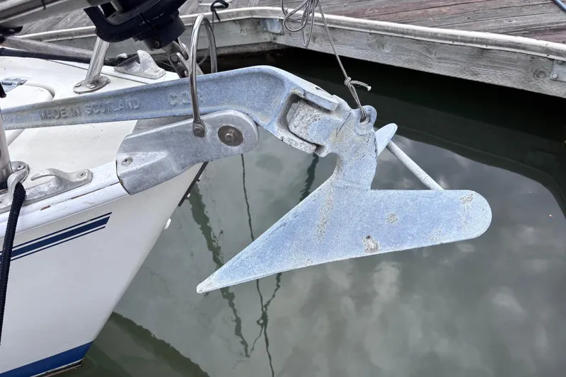 Slide: The Image of Anchor on a 1986 Pearson 28 sailboat, docked with visible water reflection. - 23