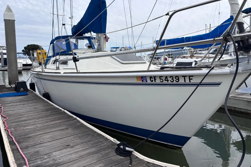 Slide: The Image of 1986 Pearson 28 sailboat docked at marina, featuring blue accents and registration number CF 5439 TF. - 3