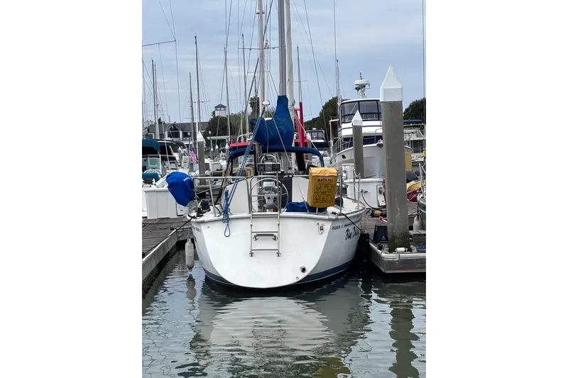 Slide: The Image of 1986 Pearson 28 sailboat docked at marina, surrounded by other boats. - 4