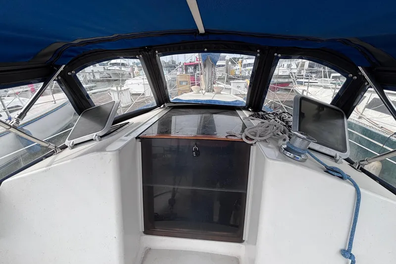 Slide: The Image of Cockpit of a 1986 Pearson 28 sailboat with blue canopy and marina view. - 5