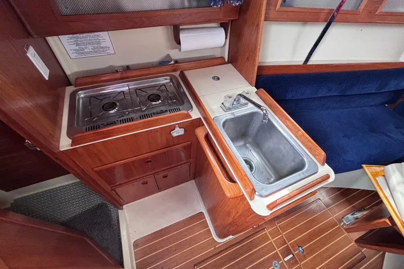 Slide: The Image of Compact galley kitchen in a 1986 Pearson 28 sailboat with stove and sink. - 9