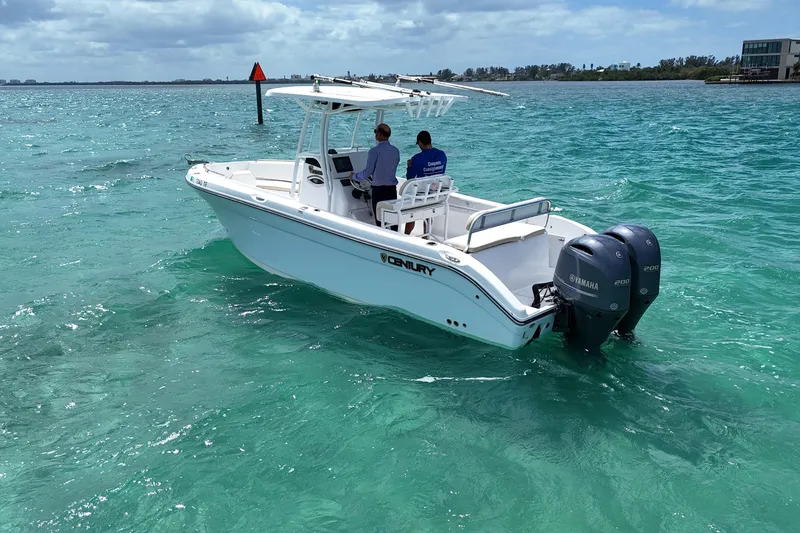 Slide: The Image of 2022 Century 2600 Center Console boat on clear turquoise water with two people onboard. - 2