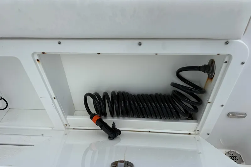 Slide: The Image of Coiled hose in storage compartment of 2022 Century 2600 Center Console boat. - 24