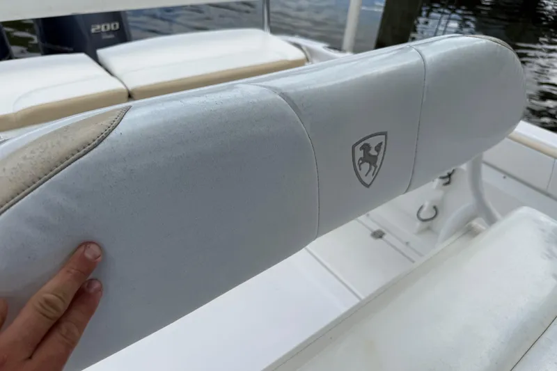 Slide: The Image of White cushioned seat on 2022 Century 2600 Center Console boat, featuring a logo. - 30