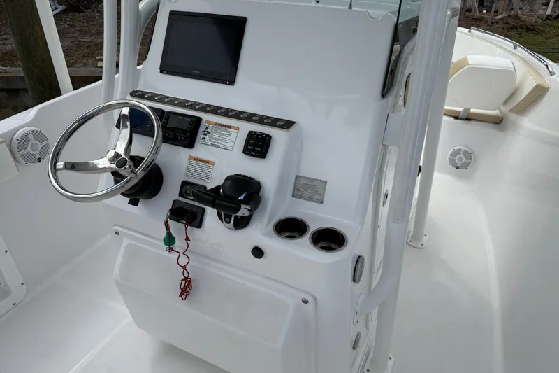 Slide: The Image of 2022 Century 2600 Center Console boat dashboard with steering wheel and electronic controls. - 39