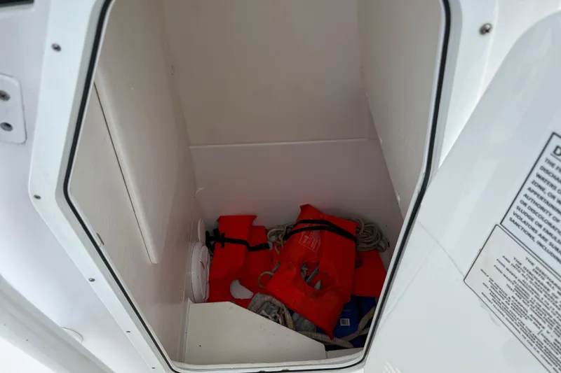 Slide: The Image of Storage compartment in 2022 Century 2600 Center Console boat with life jackets and rope. - 45
