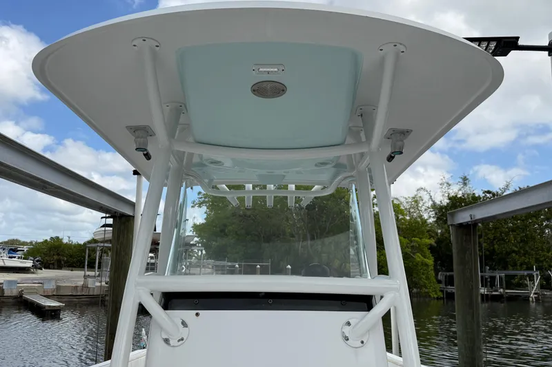 Slide: The Image of 2022 Century 2600 Center Console boat with T-top, docked under a cloudy sky. - 53