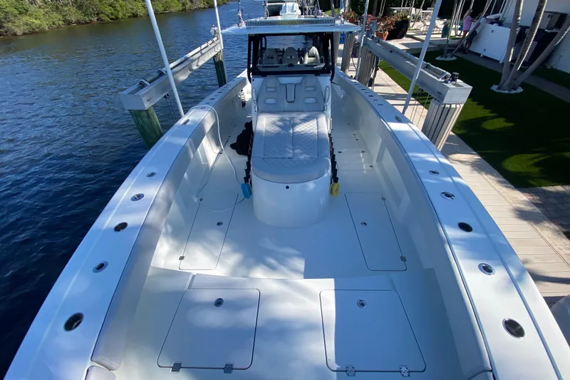 Slide: The Image of 2019 Freeman 42LR boat docked by a serene waterfront, showcasing spacious deck layout. - 27