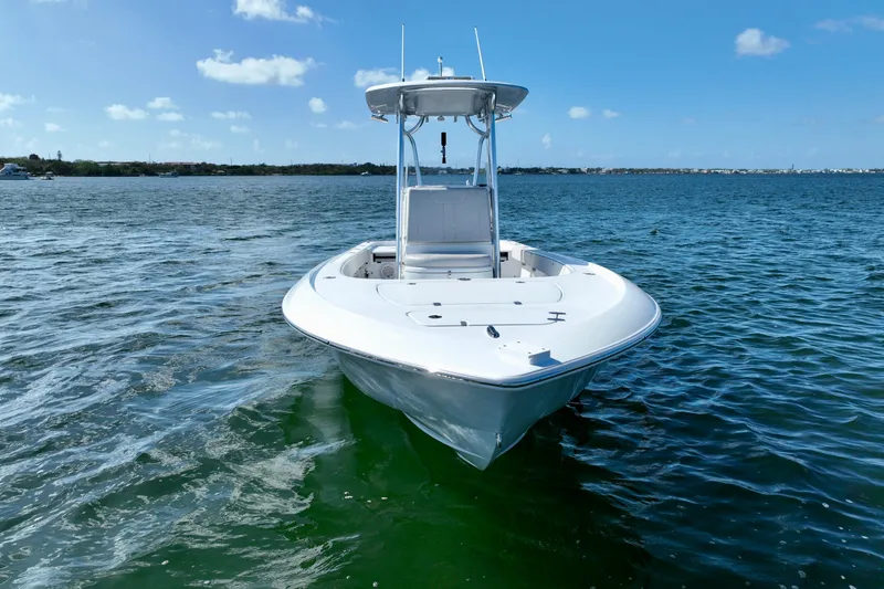 Slide: The Image of 2025 Contender 26 Bay boat on calm water under clear blue sky. - 10