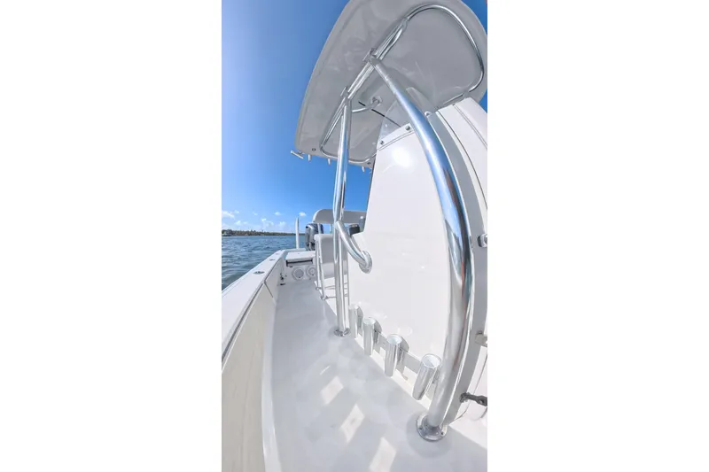 Slide: The Image of 2025 Contender 26 Bay boat with sleek design and stainless steel features on open water. - 19