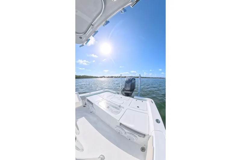 Slide: The Image of 2025 Contender 26 Bay boat on sunny water, showcasing sleek design and powerful engine. - 24