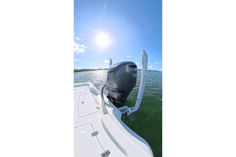 Slide: The Image of 2025 Contender 26 Bay boat with outboard motor on sunny day, ocean view. - 27