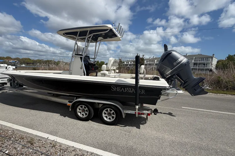 Slide: The Image of 2013 ShearWater 25 LTZ boat on trailer, featuring Yamaha outboard motor, parked roadside. - 17