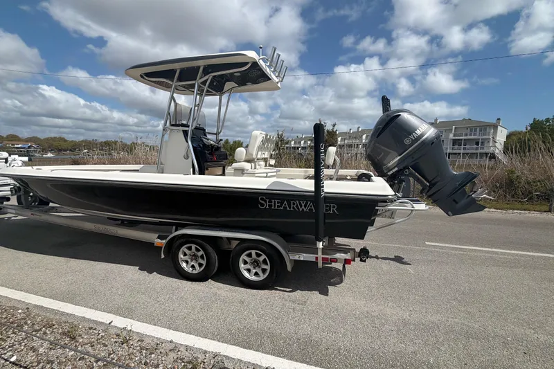 Slide: The Image of 2013 ShearWater 25 LTZ boat on trailer with Yamaha outboard motor, parked roadside. - 18