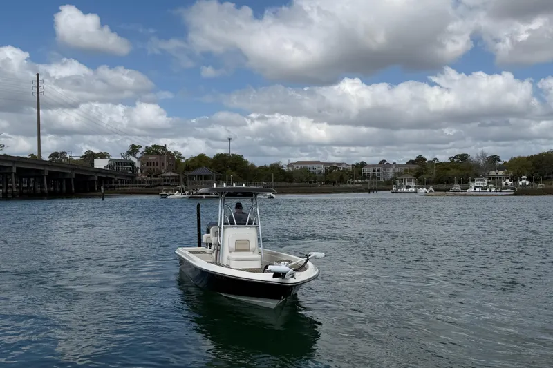 Slide: The Image of 2013 ShearWater 25 LTZ boat on a calm river under a cloudy sky. - 4