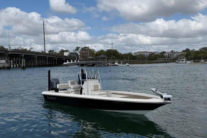 Slide: The Image of 2013 ShearWater 25 LTZ boat on water near a bridge under cloudy sky. - 6
