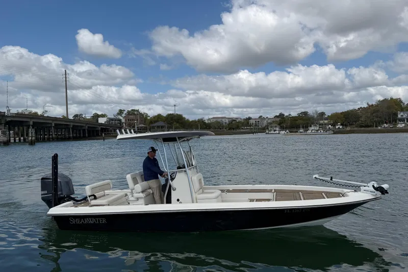 Slide: The Image of 2013 ShearWater 25 LTZ boat on calm water with bridge in background. - 9
