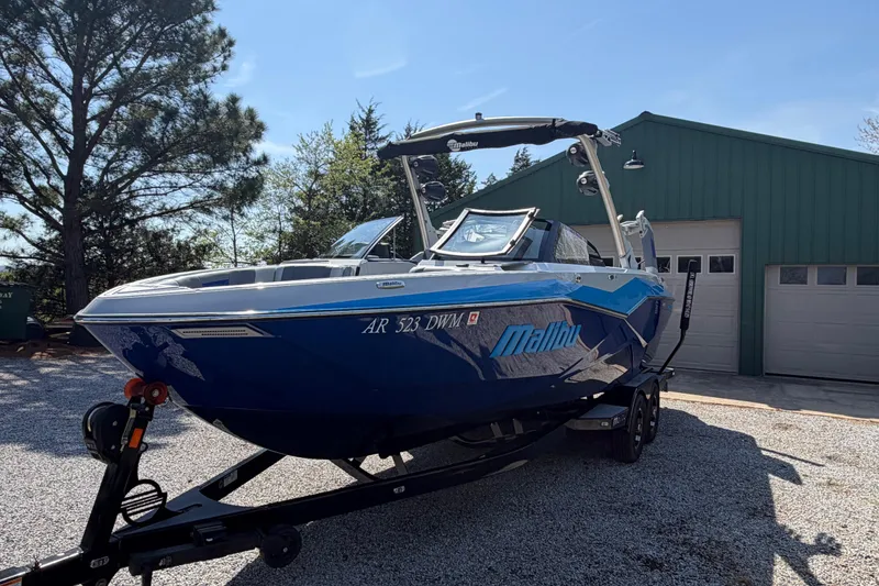 Slide: The Image of 2022 Malibu Wakesetter 25 LSV boat on trailer, parked near green garage. - 3