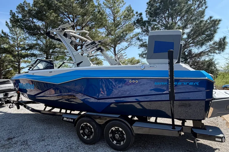 Slide: The Image of 2022 Malibu Wakesetter 25 LSV boat on trailer, blue exterior, parked outdoors. - 4