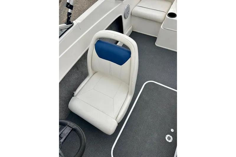 Slide: The Image of 2016 Bayliner 175 Bowrider interior with white and blue seating, gray carpet. - 19
