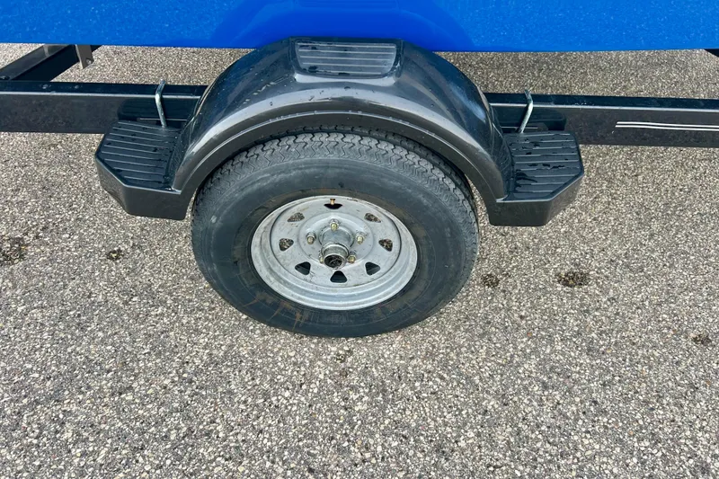 Slide: The Image of Trailer wheel of a 2016 Bayliner 175 Bowrider on asphalt surface. - 9