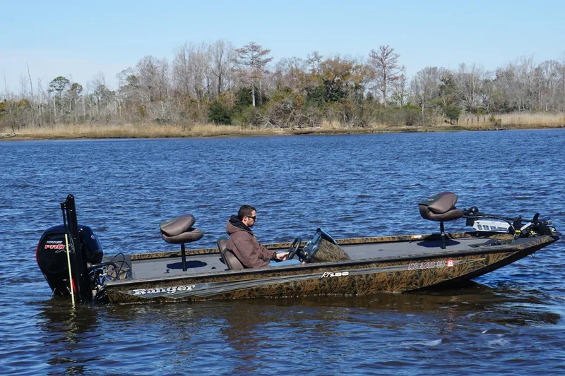 Slide: The Image of 2019 Ranger RT188P Fishing boat on a calm lake with a seated person. - 2