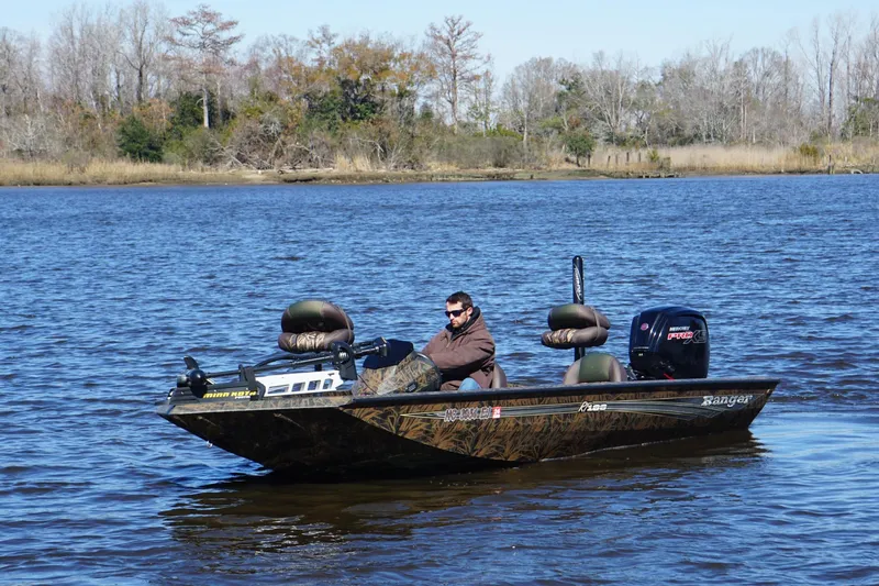 Slide: The Image of 2019 Ranger RT188P Fishing boat on a lake with a person onboard, surrounded by trees. - 5